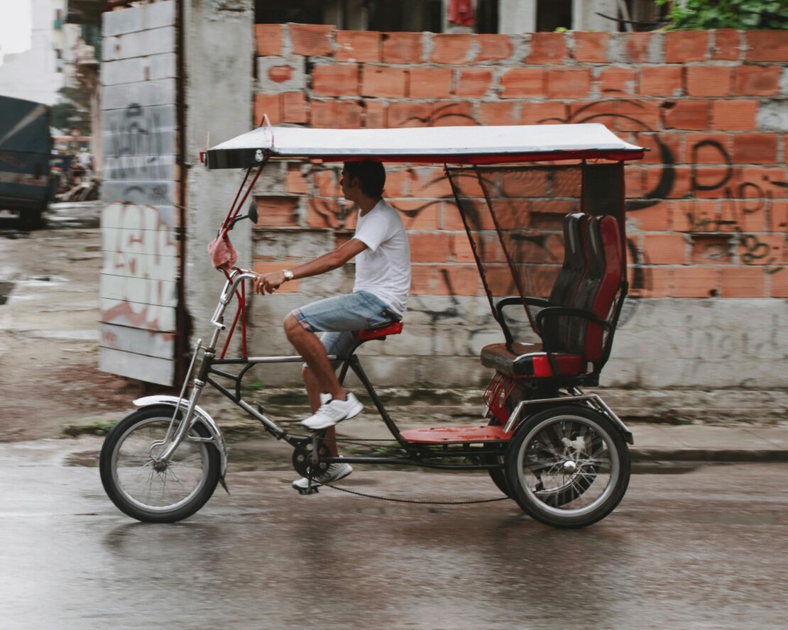 Bicitaxi transportando pasajeros en una calle urbana